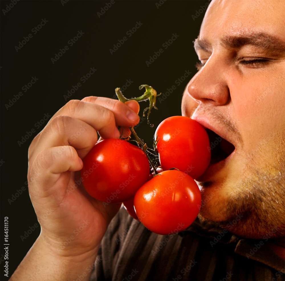 Orang makan tomat segar
